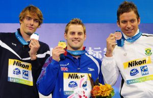 (L-R) France's silver medalist Camille Lacourt, Britain's gold medalist Liam Tancock and South Africa's bronze medalist Gerhard Zandberg celebrate on the podium during the award ceremony for the final of the men's 50-metre backstroke swimming event in the FINA World Championships at the indoor stadium of the Oriental Sports Center in Shanghai on July 31, 2011. AFP PHOTO / MARK RALSTON (Photo credit should read MARK RALSTON/AFP/Getty Images)